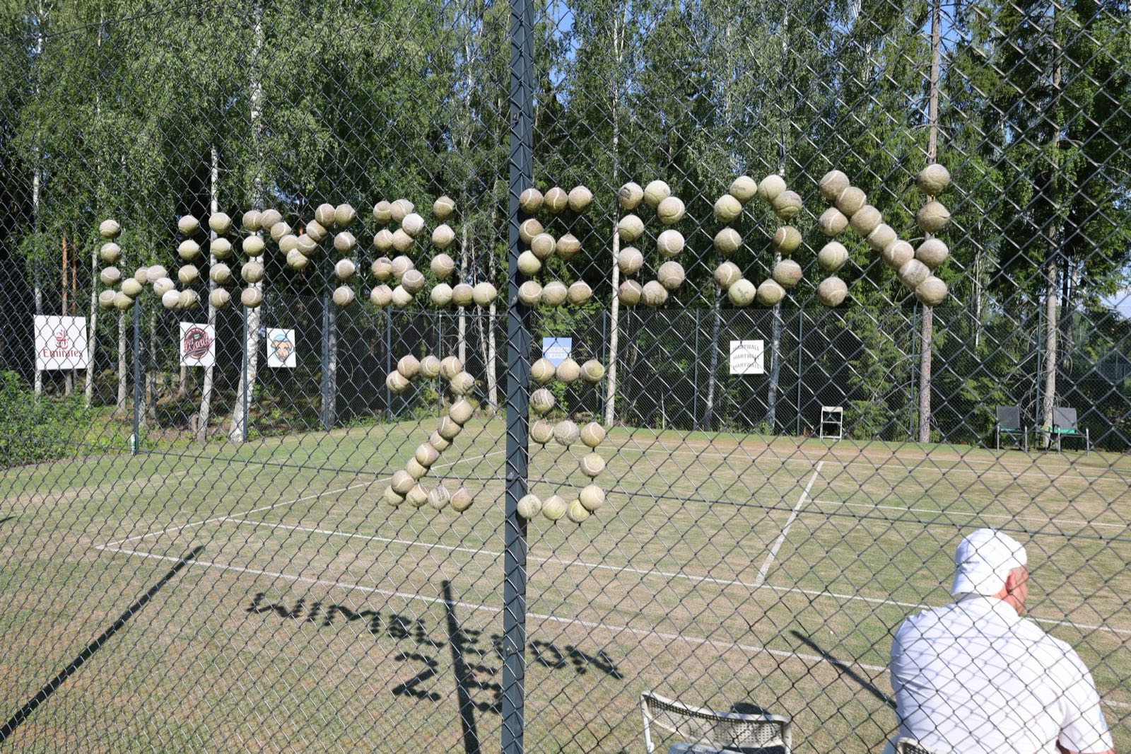 Wimbledon 25 — tennispalloista koottu teksti aidassa